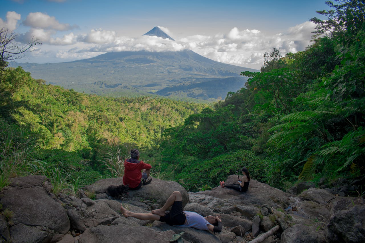 Photo of Group of People Sitting on Rock Formation